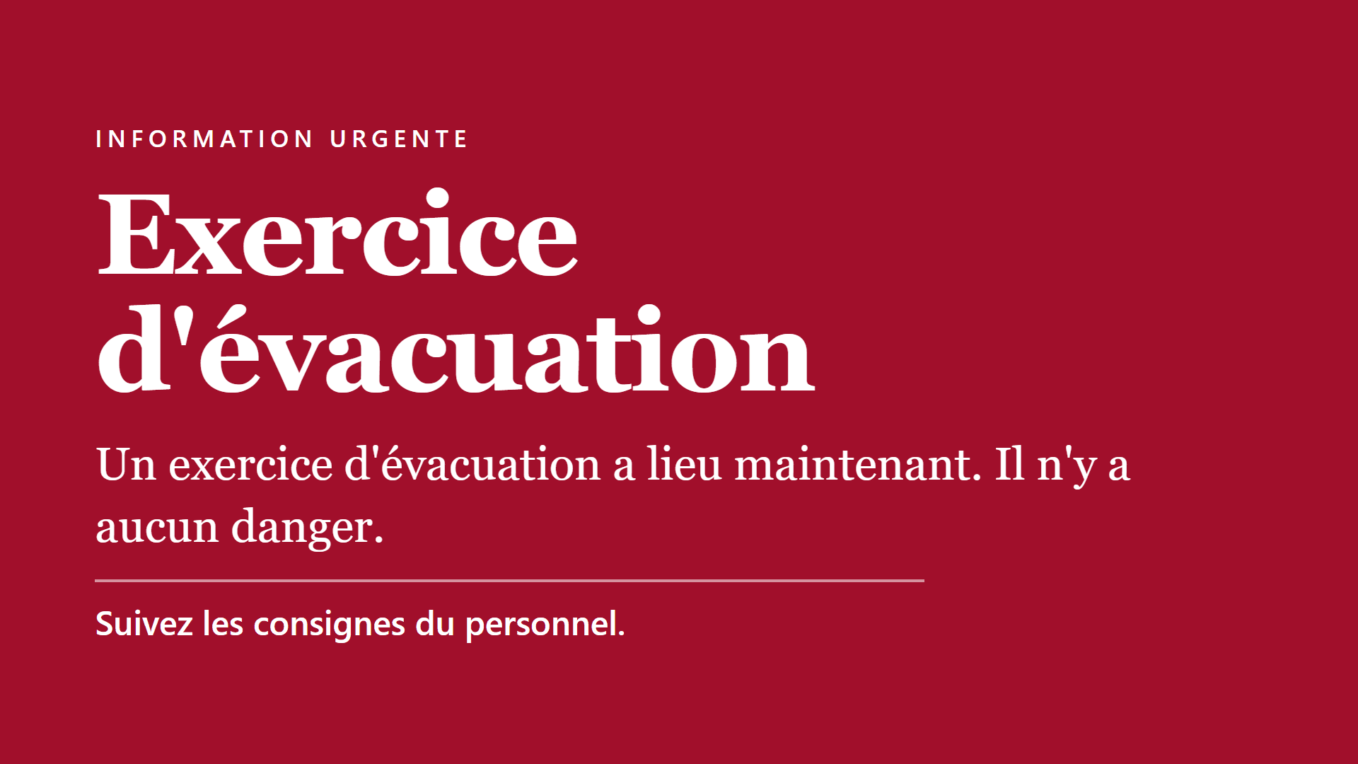 Écran de téléviseur entièrement rouge diffusant une alerte : en haut le sur-titre blanc espacé « Information urgente », puis en très grands caractères « Exercice d’évacuation », la phrase « Un exercice d’évacuation a lieu maintenant. Il n’y a aucun danger. », un filet fin, et la consigne en gras « Suivez les consignes du personnel. »